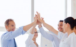 happy business team giving high five in office